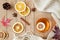 CupÂ ofÂ teaÂ withÂ lemonÂ onÂ aÂ woodenÂ tableÂ withÂ aÂ knittedÂ scarfÂ andÂ decorations